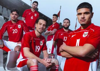 Lima pemain Timnas Indonesia mengenakan seragam merah berpose di tribun stadion.