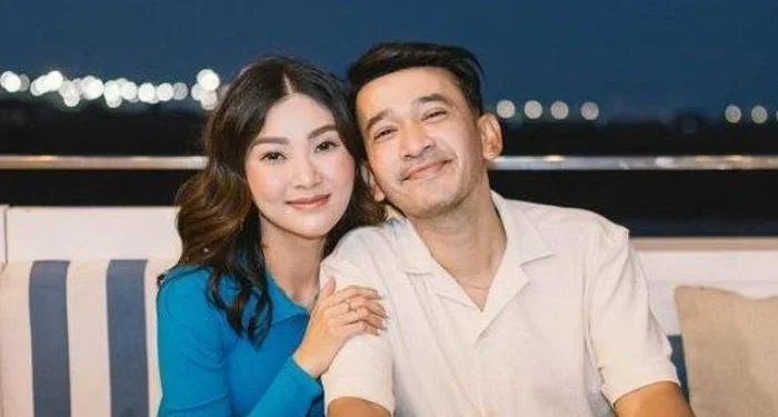 Ruben Onsu dan Sarwendah berpose bersama di tempat duduk berlatar suasana malam
