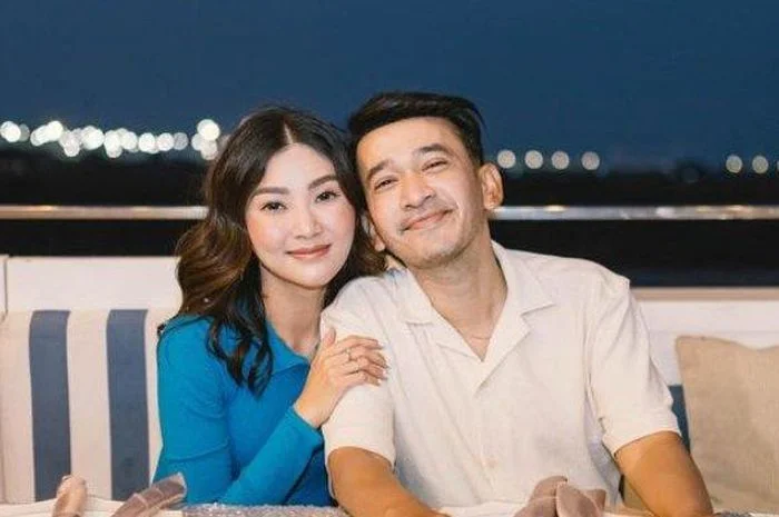 Ruben Onsu dan Sarwendah berpose bersama di tempat duduk berlatar suasana malam