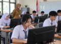 Ilustrasi siswa SMA mengerjakan ujian menggunakan komputer di ruang kelas dengan pengawas