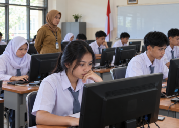 Ilustrasi siswa SMA mengerjakan ujian menggunakan komputer di ruang kelas dengan pengawas