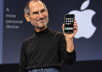 Ilustrasi karikatur Steve Jobs memegang iPhone generasi pertama