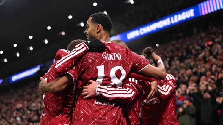 Sejumlah pemain Liverpool berseragam merah saling berpelukan merayakan gol di lapangan.