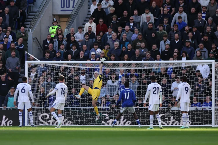 Kiper berseragam kuning melompat menghalau bola di depan gawang, dikelilingi pemain Chelsea berseragam putih dan Everton berbaju biru