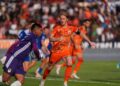 Pemain berseragam oranye Persija bergerak di dekat penjaga gawang berbaju ungu dan sejumlah pemain lawan di lapangan sepak bola