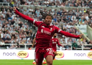 Pemain Liverpool berseragam merah nomor 73 berlari sambil merentangkan kedua tangan di hadapan tribun penonton