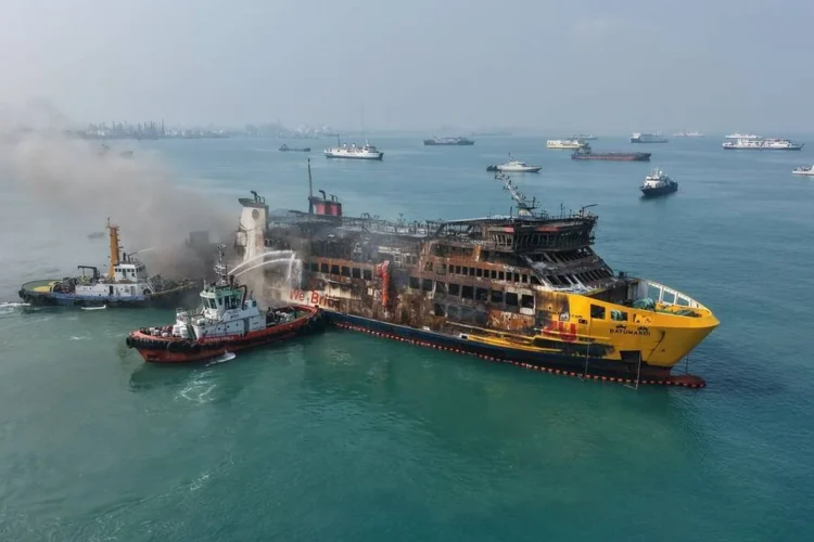 KMP Batumandi dengan bekas kebakaran dan kapal pemadam di sekitarnya