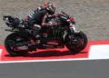 Marco Bezzecchi mengendarai motor balap Aprilia berwarna hitam dan merah di lintasan sirkuit