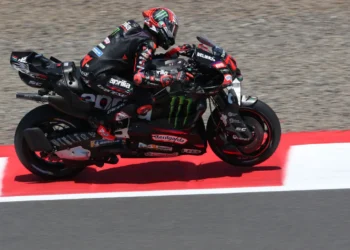 Marco Bezzecchi mengendarai motor balap Aprilia berwarna hitam dan merah di lintasan sirkuit