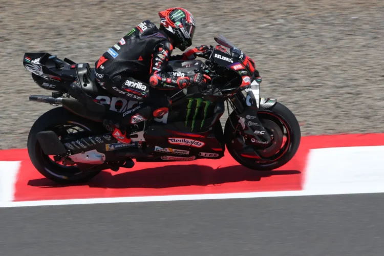 Marco Bezzecchi mengendarai motor balap Aprilia berwarna hitam dan merah di lintasan sirkuit