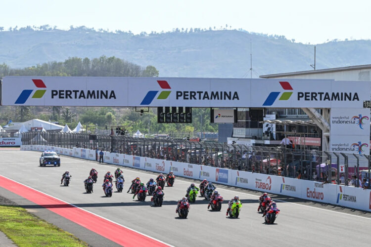Para pembalap MotoGP melaju di lintasan lurus Sirkuit Mandalika di bawah papan Pertamina.