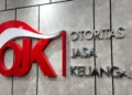 Logo Otoritas Jasa Keuangan (OJK) pada dinding berwarna abu-abu