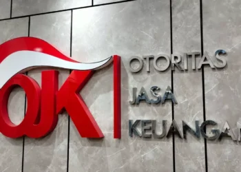 Logo Otoritas Jasa Keuangan (OJK) pada dinding berwarna abu-abu