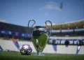 Trofi Liga Champions UEFA berdiri di lapangan sepak bola dengan bola bermotif bintang di sampingnya