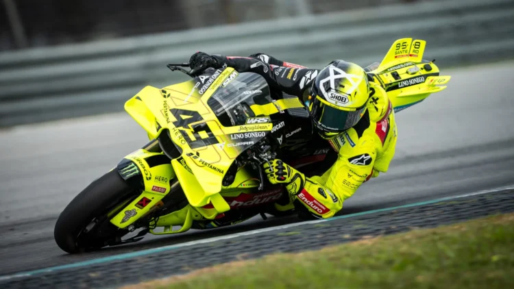 Fabio Di Giannantonio mengendarai motor balap Ducati bernomor 49 berwarna kuning saat menikung di lintasan.