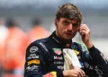 Max Verstappen mengenakan seragam balap Red Bull Racing sambil menyentuh alat komunikasi di telinganya