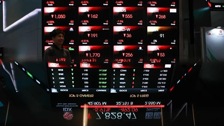 Papan elektronik menampilkan angka harga saham berwarna merah dan hijau di area perdagangan