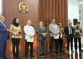 Sejumlah pejabat berdiri di depan mikrofon dalam konferensi pers di ruangan berlogo DPR RI