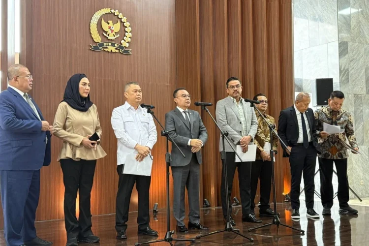 Sejumlah pejabat berdiri di depan mikrofon dalam konferensi pers di ruangan berlogo DPR RI