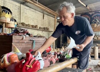 Perajin topeng klasik Ki Supono menunjukkan sejumlah topeng hasil karyanya