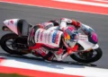 Veda Ega Pratama menunggangi motor balap Honda Team Asia bernomor 9 sambil menikung di lintasan