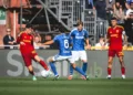 Pemain AS Roma berbaju merah dan pemain Como berseragam biru berebut bola di lapangan
