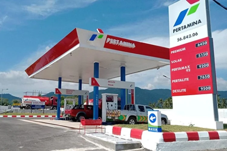 SPBU Pertamina dengan area pengisian BBM, kendaraan dan papan harga bahan bakar