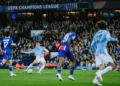 Pemain Manchester City berseragam biru muda melepaskan tembakan di antara pemain Paris Saint-Germain berseragam biru tua di lapangan
