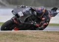 Motor balap prototipe KTM hitam bernomor 86 melaju miring di tikungan sirkuit, dengan pengendara memakai helm dan pakaian balap