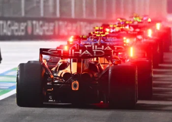 Tampak belakang sejumlah mobil Formula 1 berjajar di jalur pit dengan lampu merah menyala