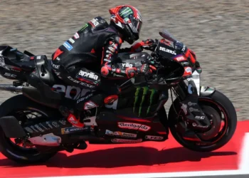 Marco Bezzecchi mengendarai motor Aprilia berwarna hitam dengan aksen merah di lintasan balap