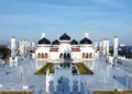 Tampak depan Masjid Raya Baiturrahman dengan kubah hitam, bangunan putih, menara dan halaman luas