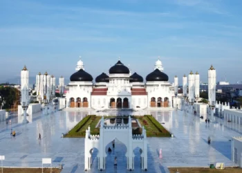 Tampak depan Masjid Raya Baiturrahman dengan kubah hitam, bangunan putih, menara dan halaman luas