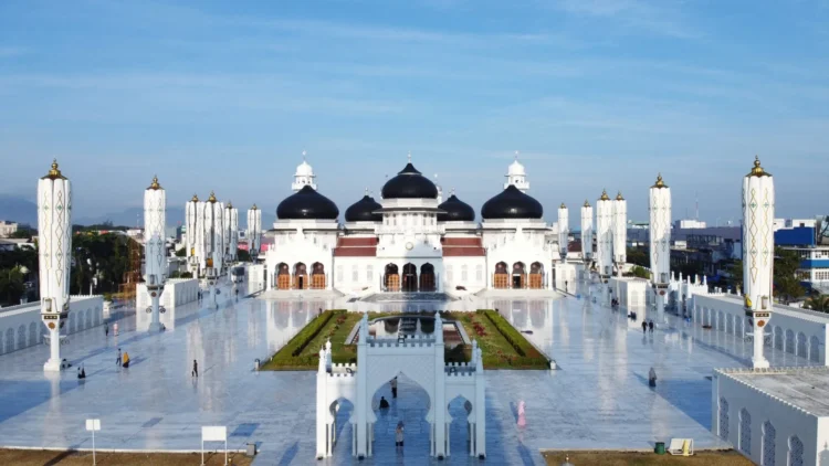 Tampak depan Masjid Raya Baiturrahman dengan kubah hitam, bangunan putih, menara dan halaman luas