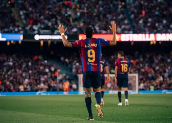 Pemain Barcelona bernomor punggung 9 dengan nama G. Jesus mengangkat kedua tangan di lapangan sepak bola