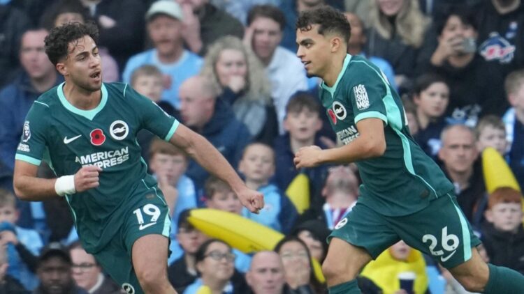 Dua pemain Brighton mengenakan seragam hijau tua merayakan gol di depan pendukung pada pertandingan melawan Manchester City